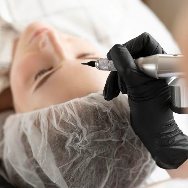 Une femme recevant un soin du visage dans un cadre relaxant, avec des produits de beauté autour d'elle.