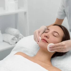 Une femme reçoit un soin du visage dans un spa, entourée d'un ambiance relaxante et apaisante.