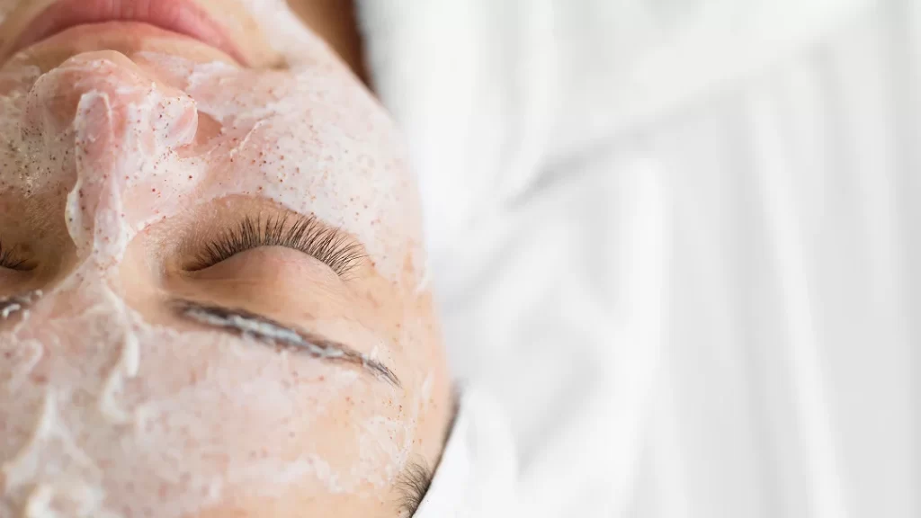 Une femme reçoit un soin du visage dans un spa, entourée d'un ambiance relaxante et apaisante.